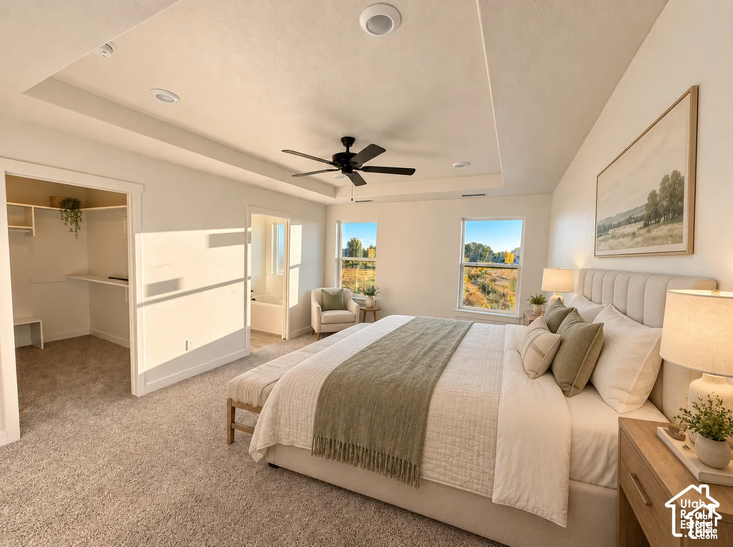 Recessed tray ceiling, neutral wall paint, ceiling fan, carpet flooring, and an organized walk-in closet-Master Bedroom