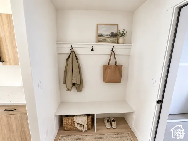 Built-in mudroom bench with integrated coat hooks and overhead shelving