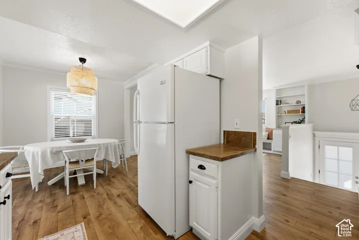 Wood-finish flooring throughout, white cabinetry with dark hardware