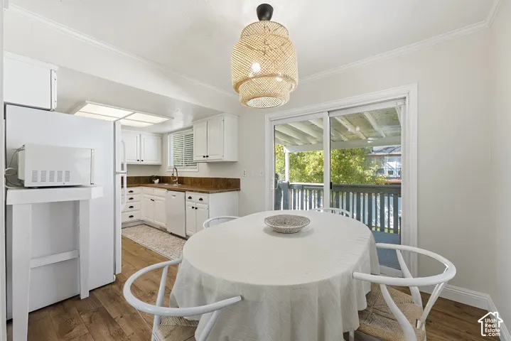 Wood-finish flooring, white cabinetry, and a sliding glass door providing access to an outdoor deck