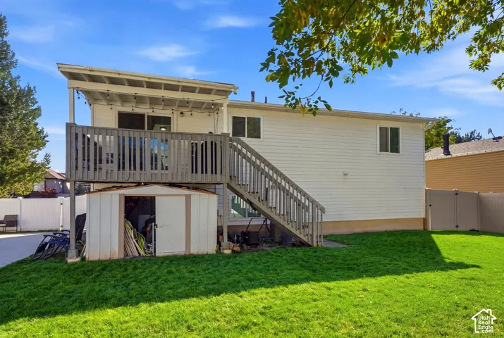 Expansive backyard with a manicured lawn, a two-story deck, a covered upper deck, and a detached storage shed