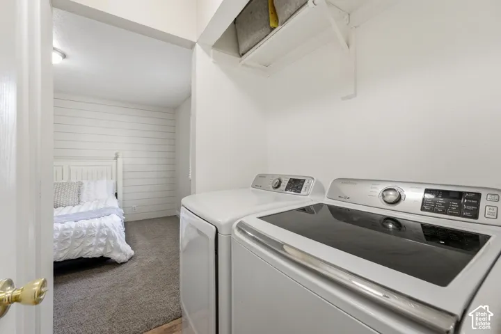Laundry area with white appliances and an overhead shelf