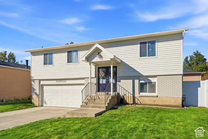Split-level exterior featuring white siding and brick detailing