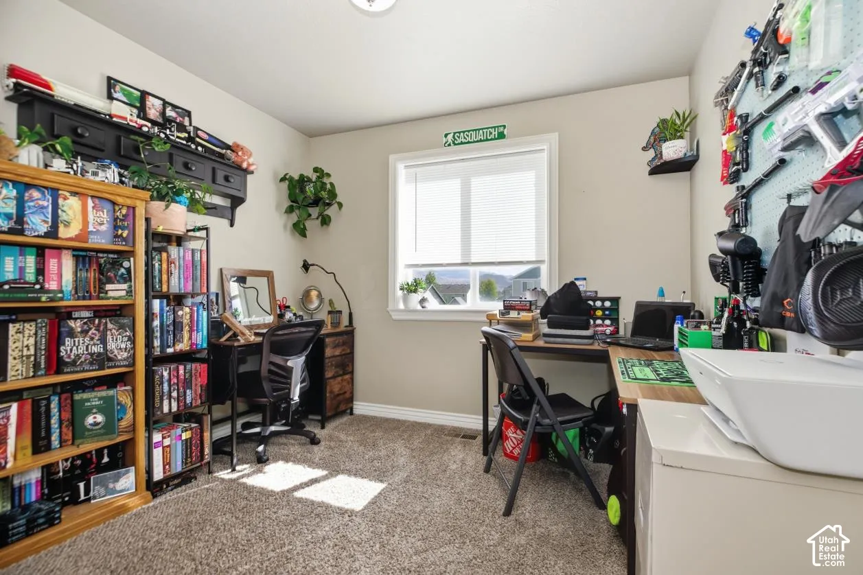 Neutral wall paint, carpet flooring, a window with blinds, and built-in shelving