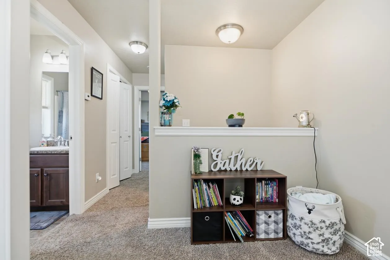Carpeted hallway with flush-mount lighting