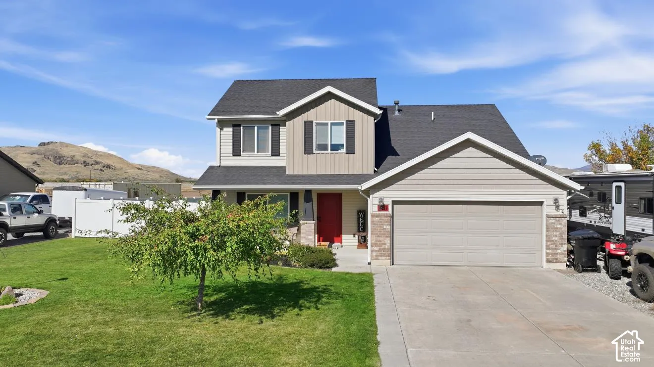 Two-story residence featuring a gray asphalt shingle roof, light-colored siding, and a two-car attached garage