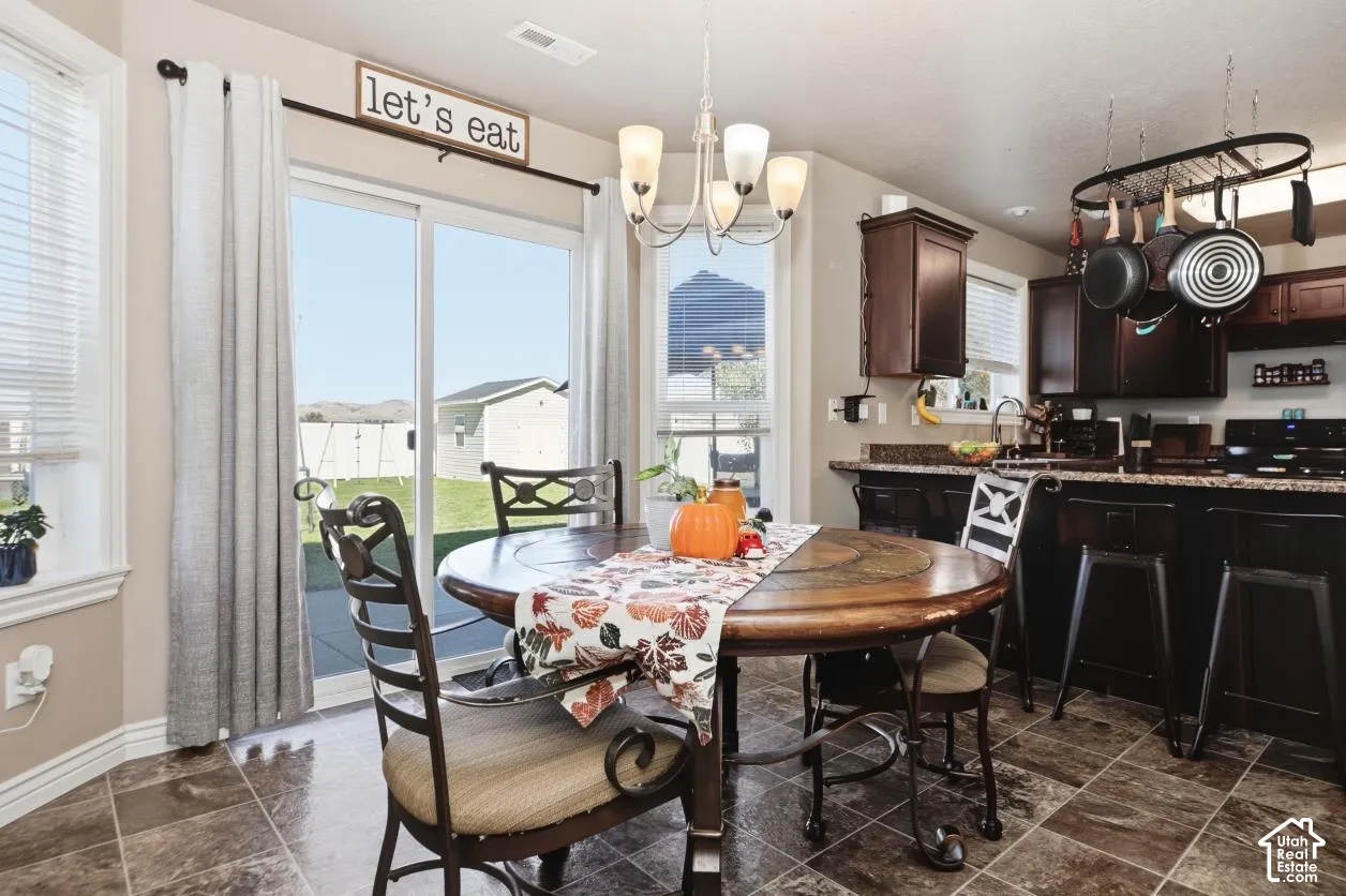 Kitchen with dark wood cabinetry, a pot rack, and a tiled floor