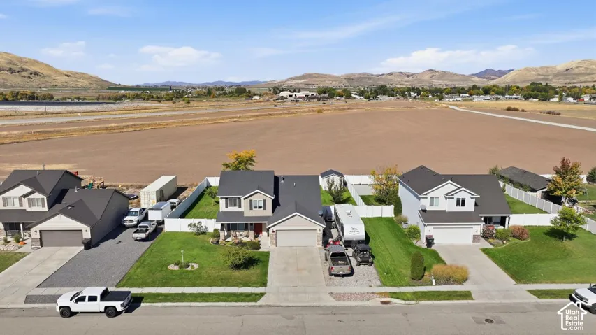 Expansive lot with a grass lawn, white privacy fencing, and an outbuilding