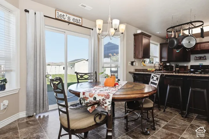 Kitchen with dark wood cabinetry, a pot rack, and a tiled floor