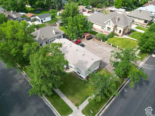 Expansive paved parking area, mature trees, and a flat roofline