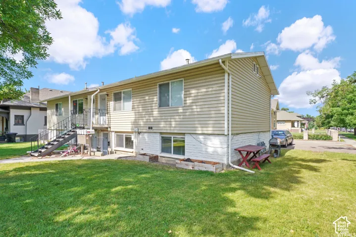 Expansive backyard featuring a manicured lawn, multi-level exterior access, and a durable siding exterior