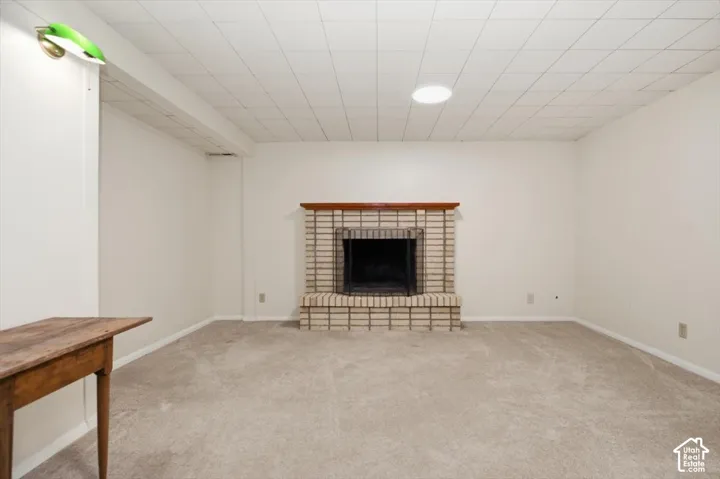 Basement family room. Brick fireplace with a wood-finish mantel