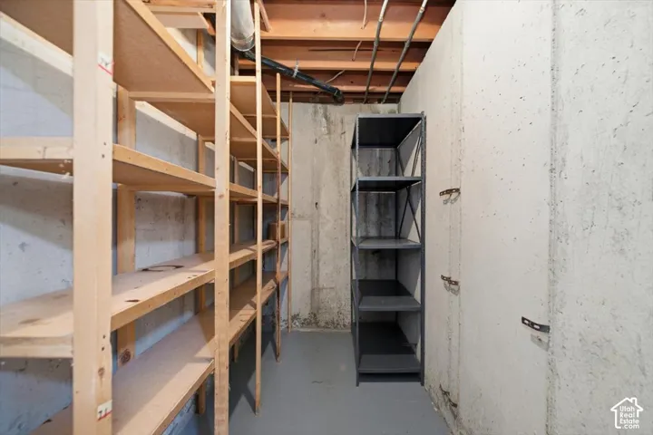 Cold storage. Concrete walls with exposed ceiling joists and utility lines