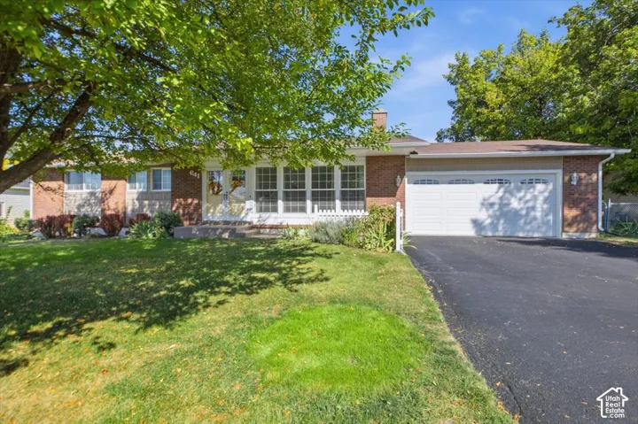 Brick and stone exterior with a white front porch and a two-car garage
