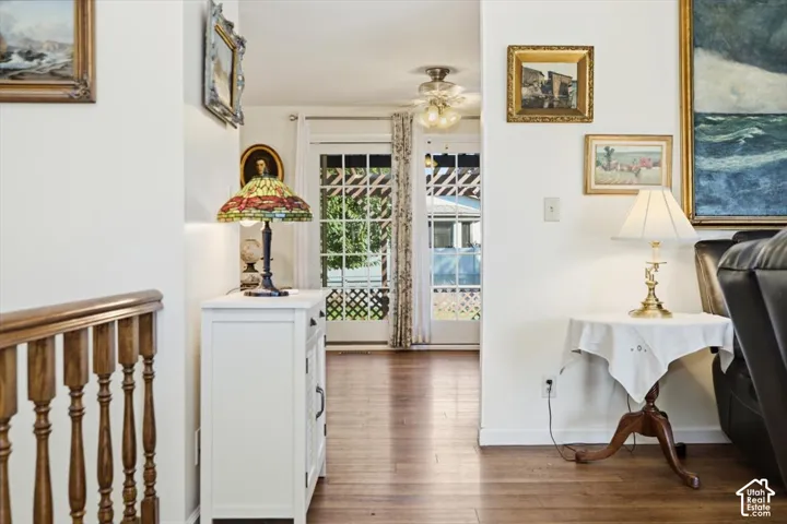 Hardwood flooring throughout, white walls, and a wood banister