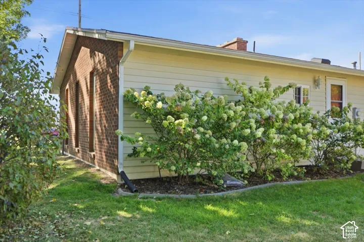 Brick exterior wall, horizontal siding, well-maintained landscaping, gutters, and downspout