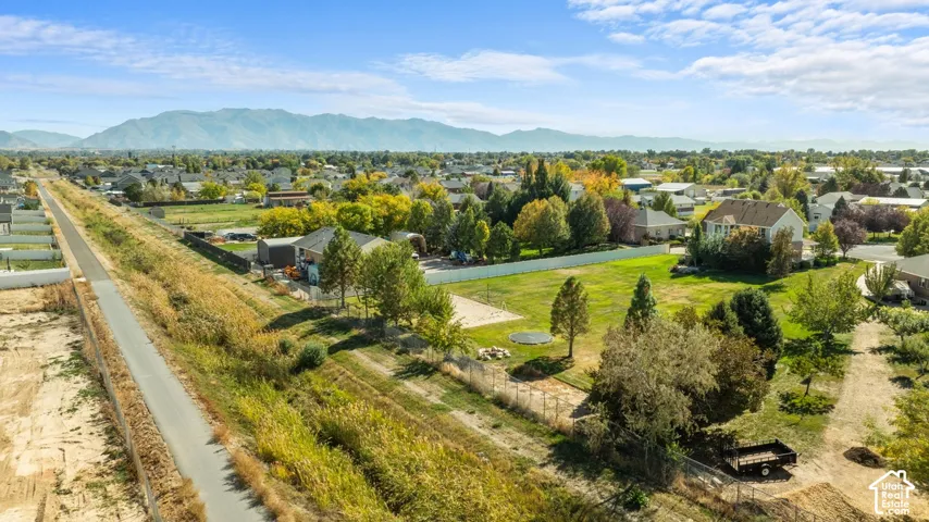 Expansive property featuring a paved trail, mature trees, and mountainous scenery