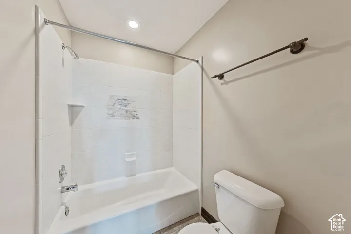 Bathtub with tiled surround, recessed soap dish, and an integrated shower head