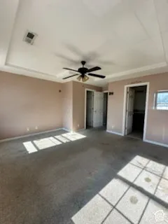 Tray ceiling featuring a central ceiling fan
