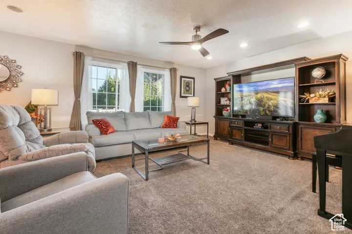 Recessed lighting, ceiling fan, carpet flooring, and a built-in media center with shelving