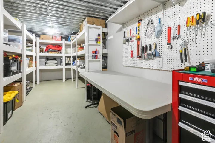 Dedicated workspace featuring a built-in workbench, pegboard organization system, and overhead lighting
