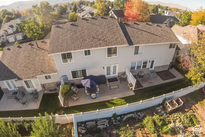 Multiple roof lines, stucco exterior, stone veneer accents, concrete patios, and white fencing
