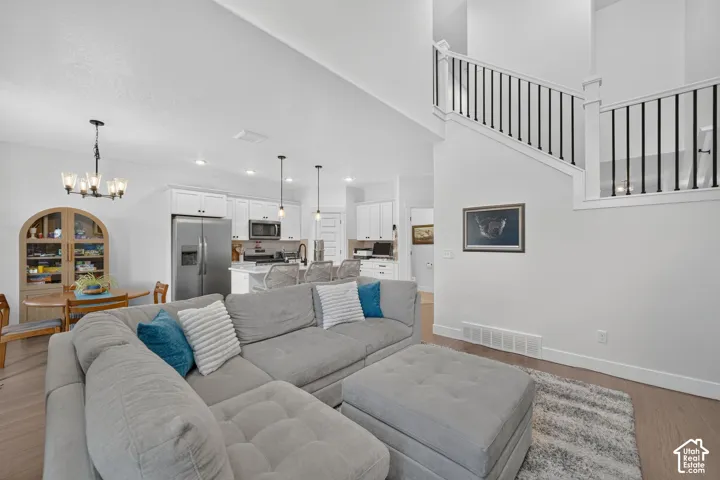 Open-concept living space featuring a gray upholstered sectional, wide-plank wood-finish flooring, and a neutral area rug