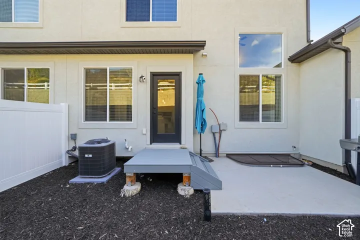 Contemporary patio featuring a concrete deck with integrated seating platforms, dark mulch landscaping, and direct access to the home's glass sliding doors