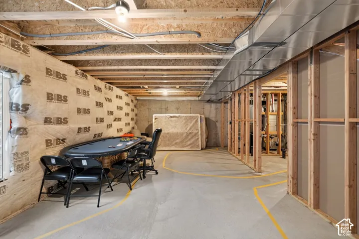 Unfinished basement with concrete flooring, exposed ceiling infrastructure, and framed interior walls