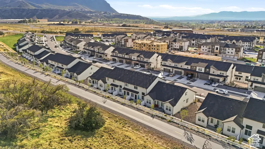 Modern townhome community with varied architectural styles, attached garages, and a paved street