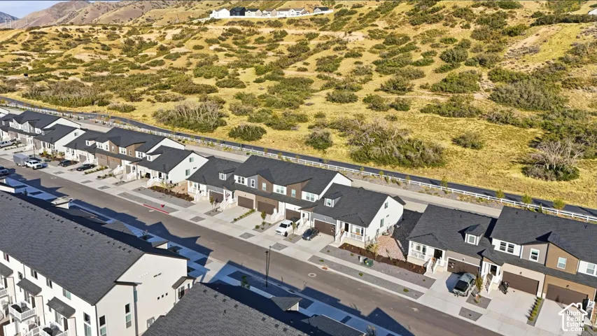 Modern residential community with uniform architectural styles, dark shingle roofing, attached garages, and landscaping