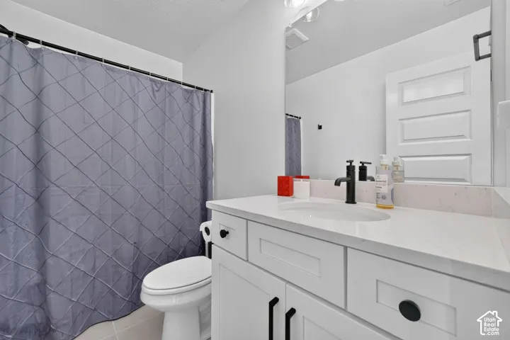 White shaker-style vanity with a quartz countertop and integrated sink