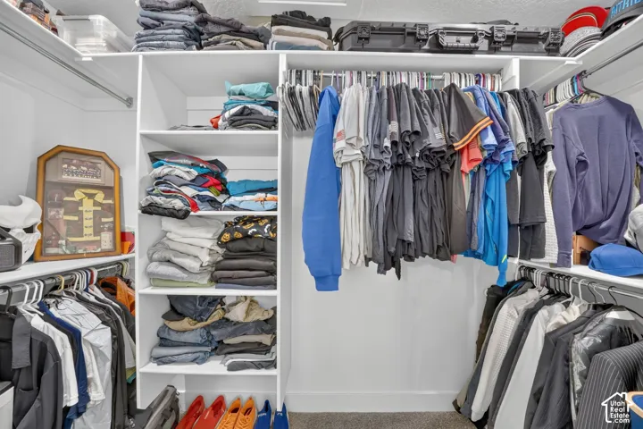 Custom closet system with multiple shelving units and ample hanging storage