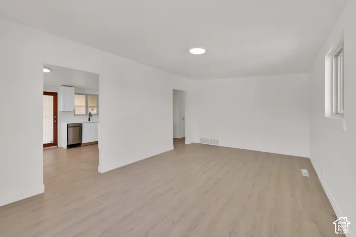 Spacious interior with wood-finish flooring, recessed ceiling lighting, and crisp white walls