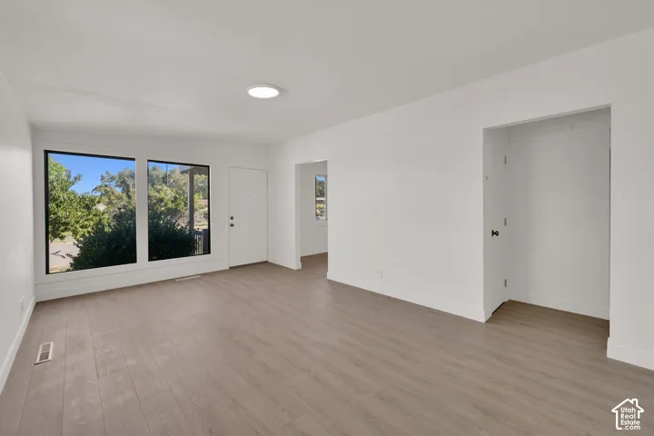 Bright interior with wood-finish flooring, recessed lighting, and large picture windows