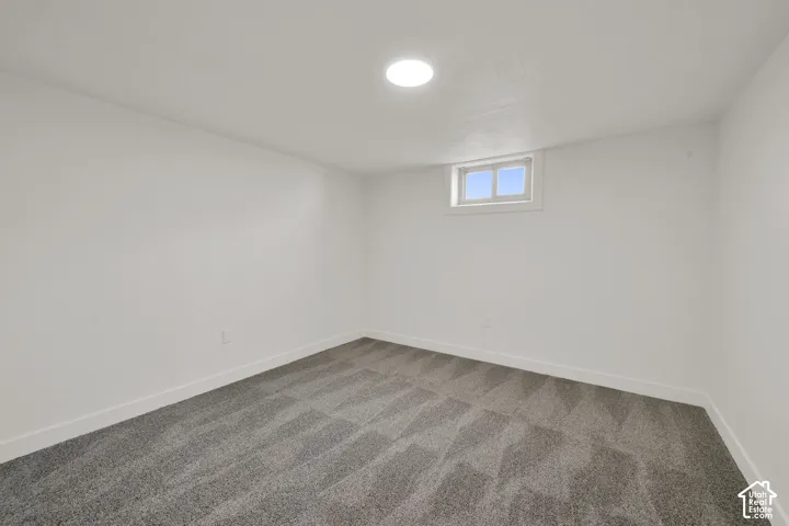 Recessed window, white walls, gray patterned carpeting, and flush-mount ceiling lighting