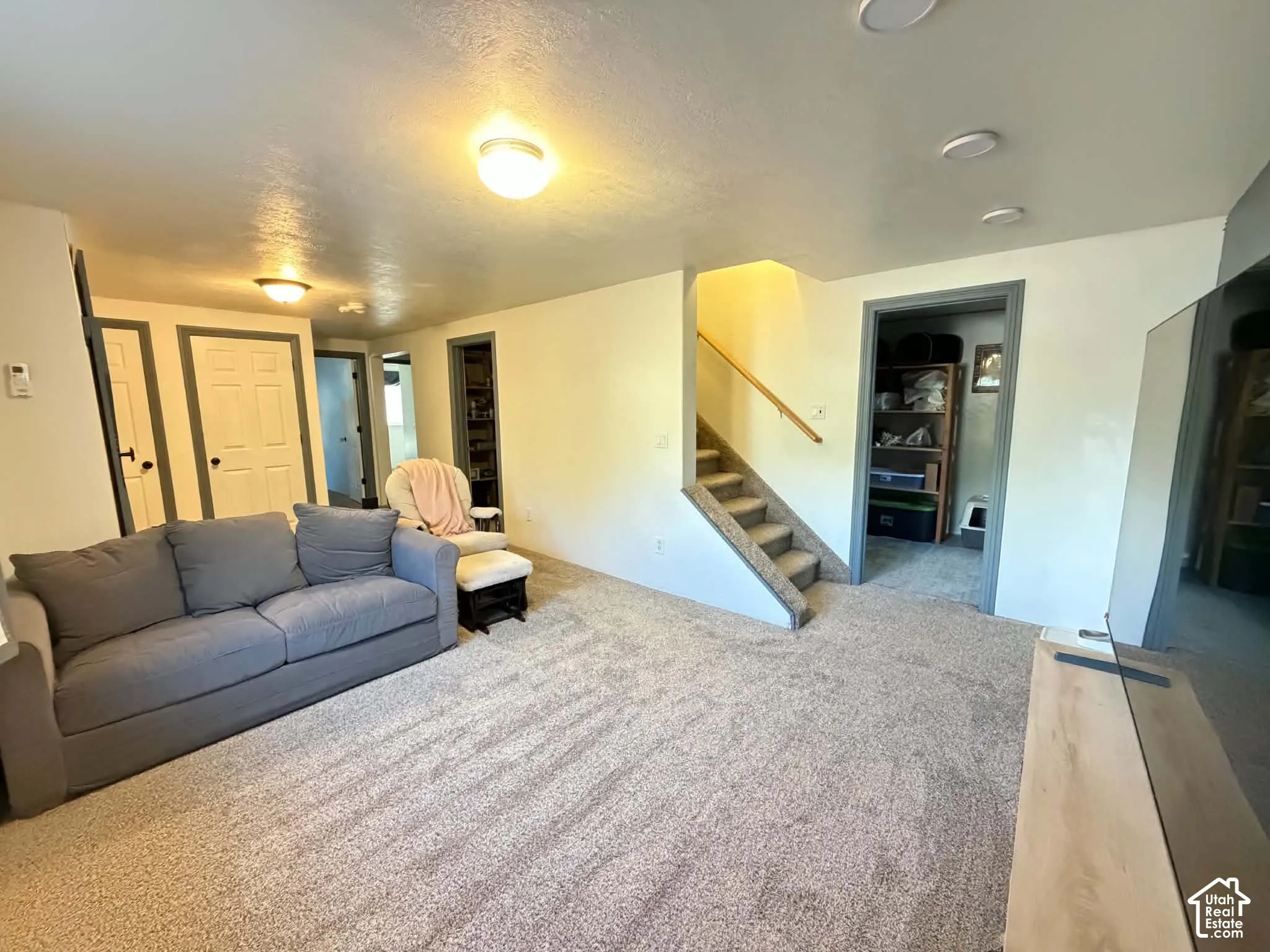 Plush carpet flooring throughout, staircase with wood railing, recessed lighting, and flush mount lighting fixtures