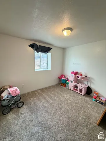 Textured walls, recessed window, wall-mounted light fixture, light-toned carpeting