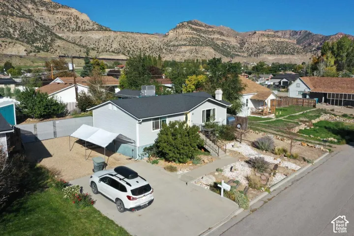 Single-story residence featuring light-colored siding, a dark-toned roof, and a front yard with xeriscaping
