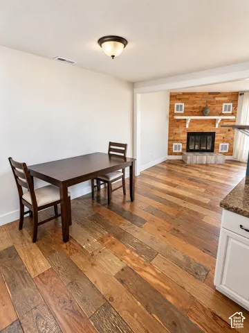 Wood-finish flooring throughout, featuring a recessed fireplace with a natural wood-finish accent wall