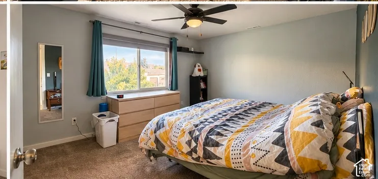 Expansive window providing natural illumination, ceiling fan with integrated lighting, and neutral wall tones