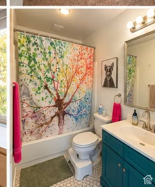 Bathroom with white tub/shower combination, white toilet, and a teal vanity with a white basin