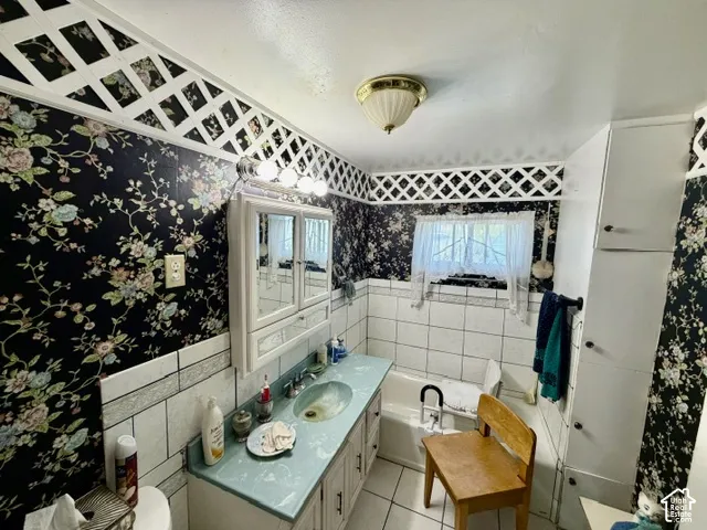 Bathroom featuring a vanity with an integrated sink, built-in medicine cabinet, tiled bathtub surround, and a coordinating built-in storage cabinet