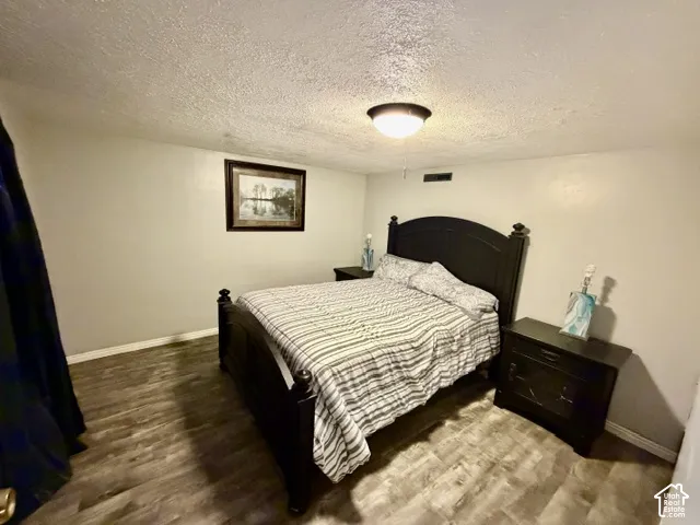 Wood-finish flooring with light-colored walls and a semi-flush mount ceiling light fixture