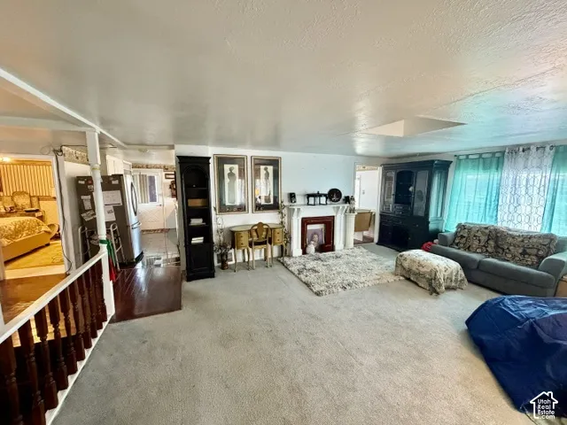 Carpeted living area featuring a decorative fireplace surround