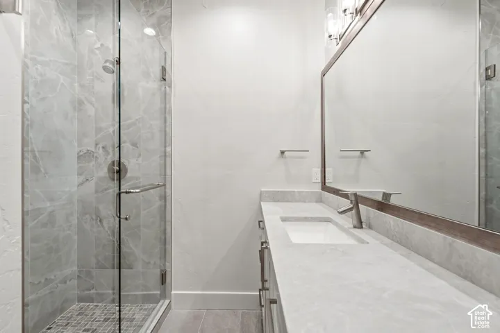 Glass-enclosed shower with tiled walls and a mosaic-tiled floor