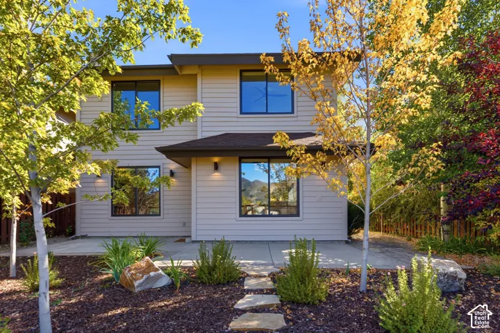 Two-story exterior with horizontal siding, dark-framed windows, and a covered entry