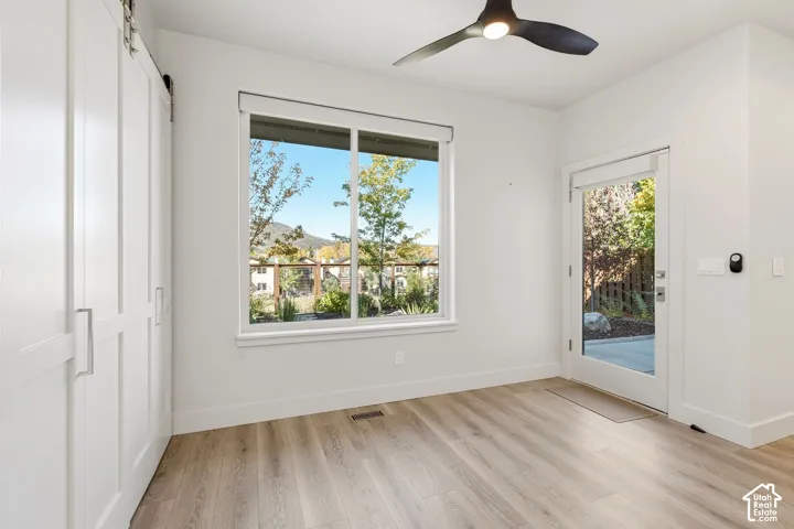 Wood-finish flooring, white walls, and a large window