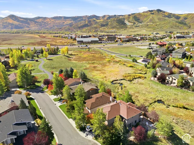 Mountain backdrop, residential street, paved pathways, varied mature trees, and natural landscape