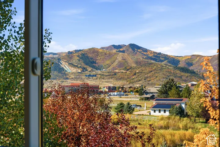 Mountain scenery with varied foliage, distant structures, and clear sky